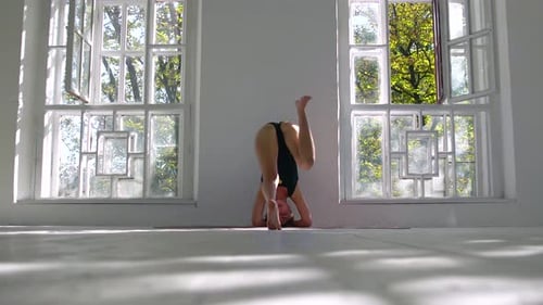 Attractive Slim Concentrated Caucasian Woman Practicing Yoga. The Girl Standing on Her Head