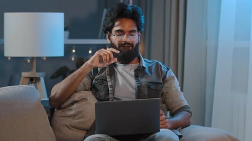 Man Using Laptop on Couch at Home