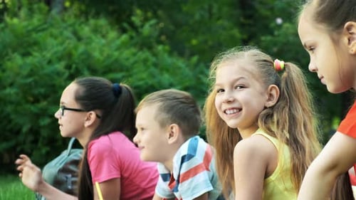 Children Sitting Together and Smiling in the Park