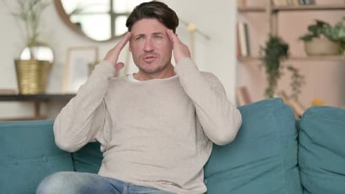 Stressed Middle Aged Man with Headache, at Home