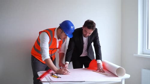 Construction Team Reviewing Blueprints in Workplace