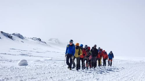 Touristen erkunden Berge Menschen mit Rucksäcken und Stöcken laufen über verschneite Hänge