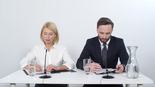 Man and Woman Working Together at Conference Table