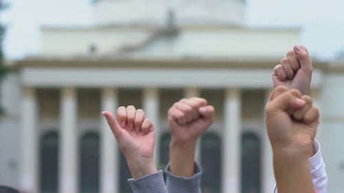 Activists Raising Fists on Government Building Background, Human Rights Rally