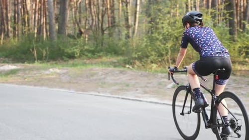 Female cyclist is riding bicycle
