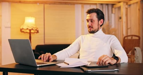Man Working on Laptop at Home Office Desk