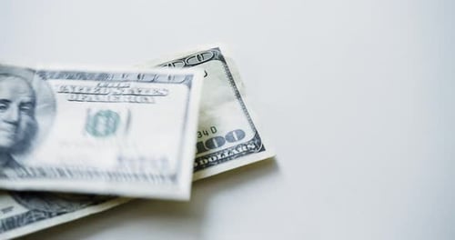 American Banknotes of Different Denominations Fall on a White Table