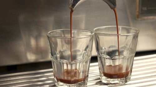 Close Up of Espresso Pouring into Two Glasses