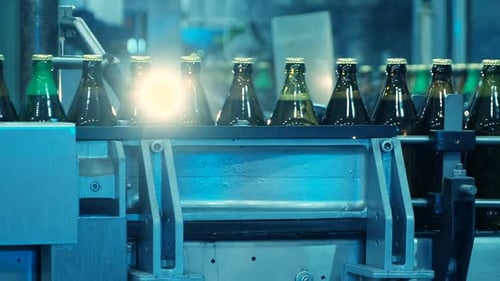 Bottles Move Along Automated Conveyor Belt in Factory