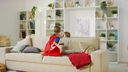 Children in Superhero Costumes Playing on Couch