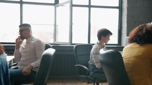Dolly Shot of Multiethnic Group of Businesspeople Working in Open Plan Office at Desks