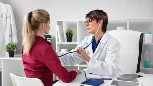 Doctor Examining Patient with Stethoscope in Clinic
