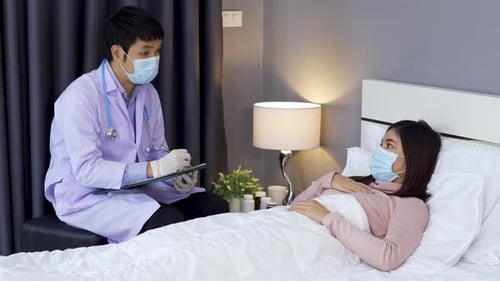 sick woman suffering in bed at home, her husband checking temperature with thermometer.