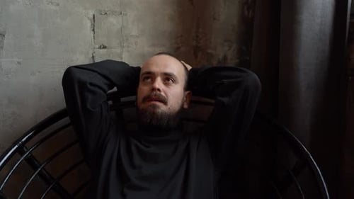Bearded Man Sitting in Chair Looking Upward