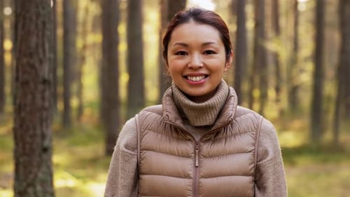 Glücklich lächelnde asiatische junge Frau im Wald