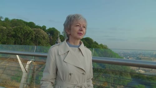 Woman Standing on Bridge Looking at City Skyline