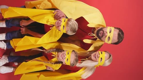 Fun Family Dressed as Superheroes on Red