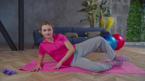 Woman Lying on Yoga Mat Doing Leg Exercise