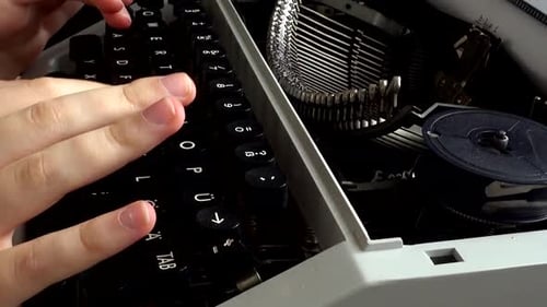 The girl is typing on a retro typewriter.