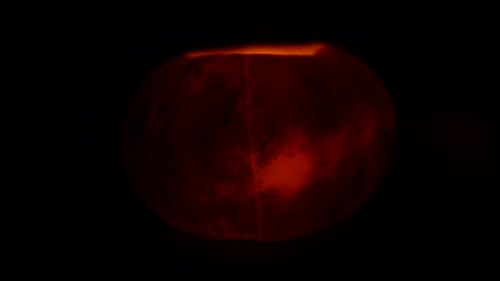 Jack's Halloween Pumpkin Lantern with a Candle Inside Rotation on Its Axis on a Black Background.