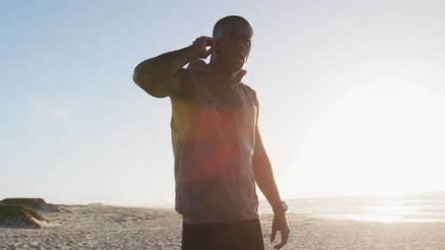 Young Adult Checking Smart Watch on Beach at Sunrise