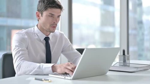 Sick Man Coughing While Working on Laptop