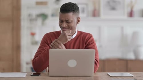 African Man having Wrist Pain while using Laptop in Office