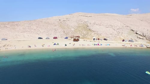 Flying above tourists on isolated beach of Pag island, Croatia