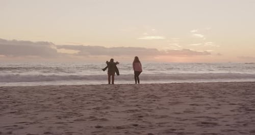Active senior couple jumping on beach
