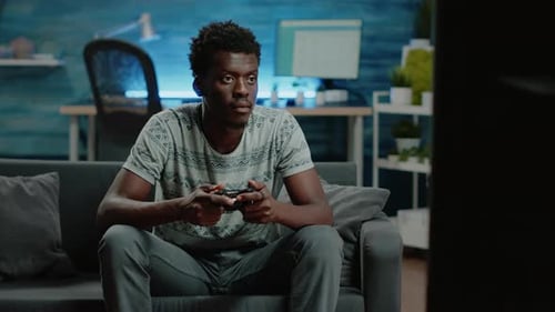 Young Adult Engrossed in Video Game at Home