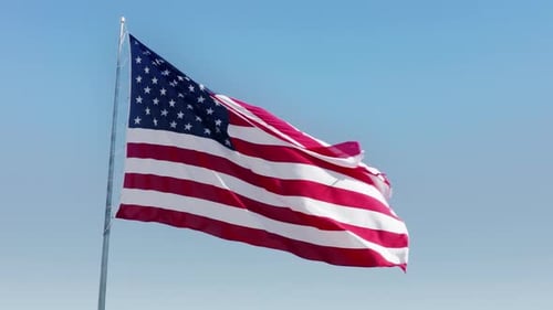 American Flag Waving Against Blue Sky