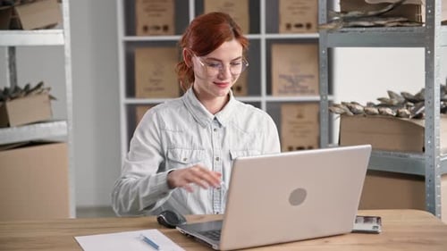 Pretty Young Woman Works in Fish Warehouse and Takes Orders Online While Sitting at Table with