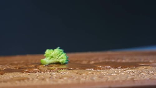 Broccoli Florets Falling in Slow Motion on Wet Surface