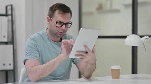 Man Using Tablet at Desk in Office