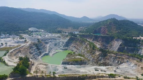 Aerial view of machine excavator trucks dig coal mining or ore with black grunge ground in quarry