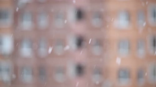 Snowfall Against Unfocused Highrise Building with Windows