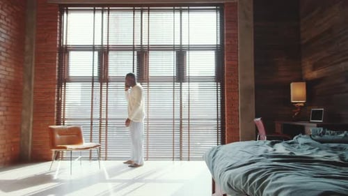 Man in Pajamas Talking on Cellphone Indoors