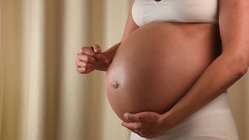 Junge schwangere Frau testet ihren exponierten Bauch