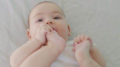 Infant Lying on Back Playing with Feet