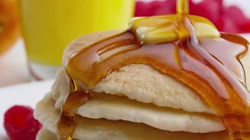 Pouring syrup onto pancakes
