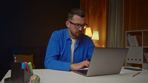 Man Typing on Laptop with Frustration and Joy