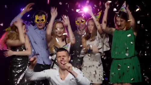 Junge Leute tanzen und werfen Glitzer-Konfetti auf der Party