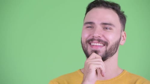 Gesicht eines glücklichen jungen gutaussehenden bärtigen Mannes