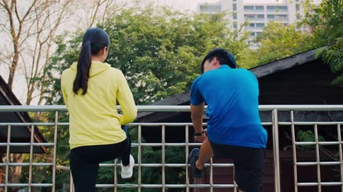 Athletic People Stretching Quads Outdoors in Urban Park