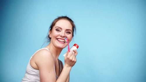 Smiling Woman Holding Toothbrush and Toothpaste
