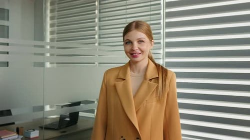 Portrait of business woman smiling on camera standing in office.