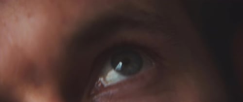 Close up of a man's blue eye staring upwards
