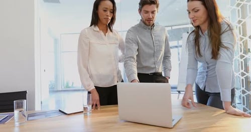 Business colleagues discussing over laptop 4k