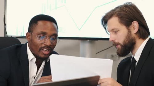 Two Businessmen in Suits Having a Discussion at Office