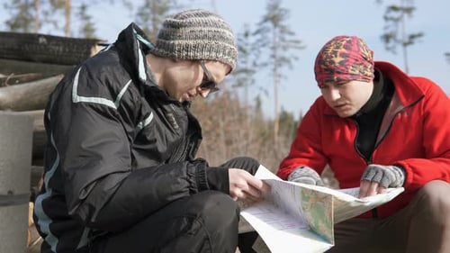 Two Men Consulting Map in a Forest